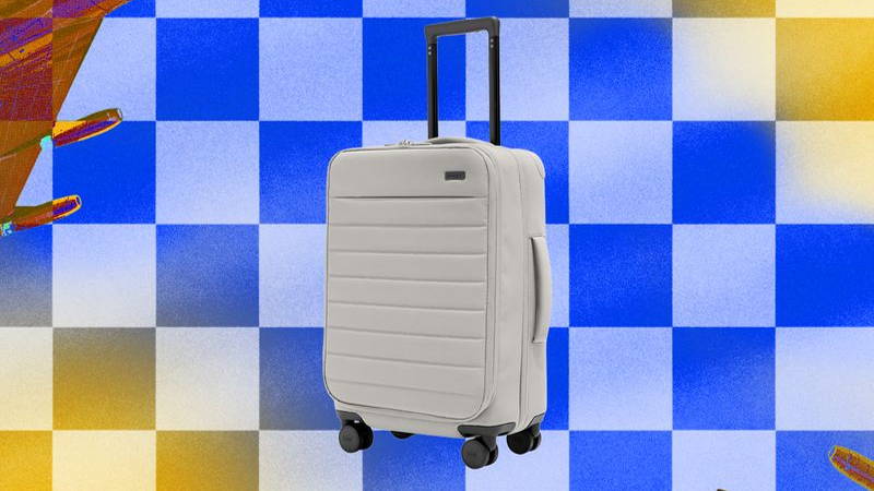 White roller luggage on checkered background
