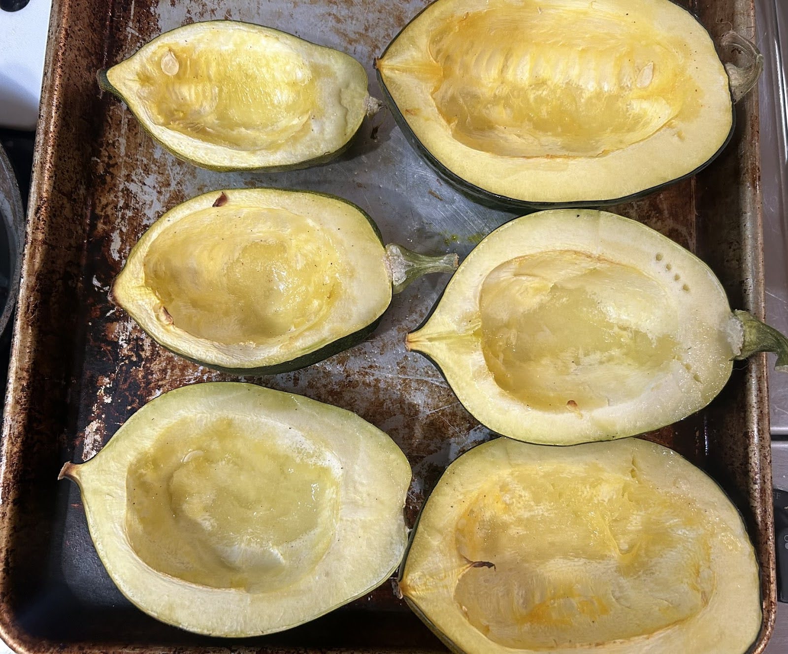 Prepared acorn squash halves on a baking sheet