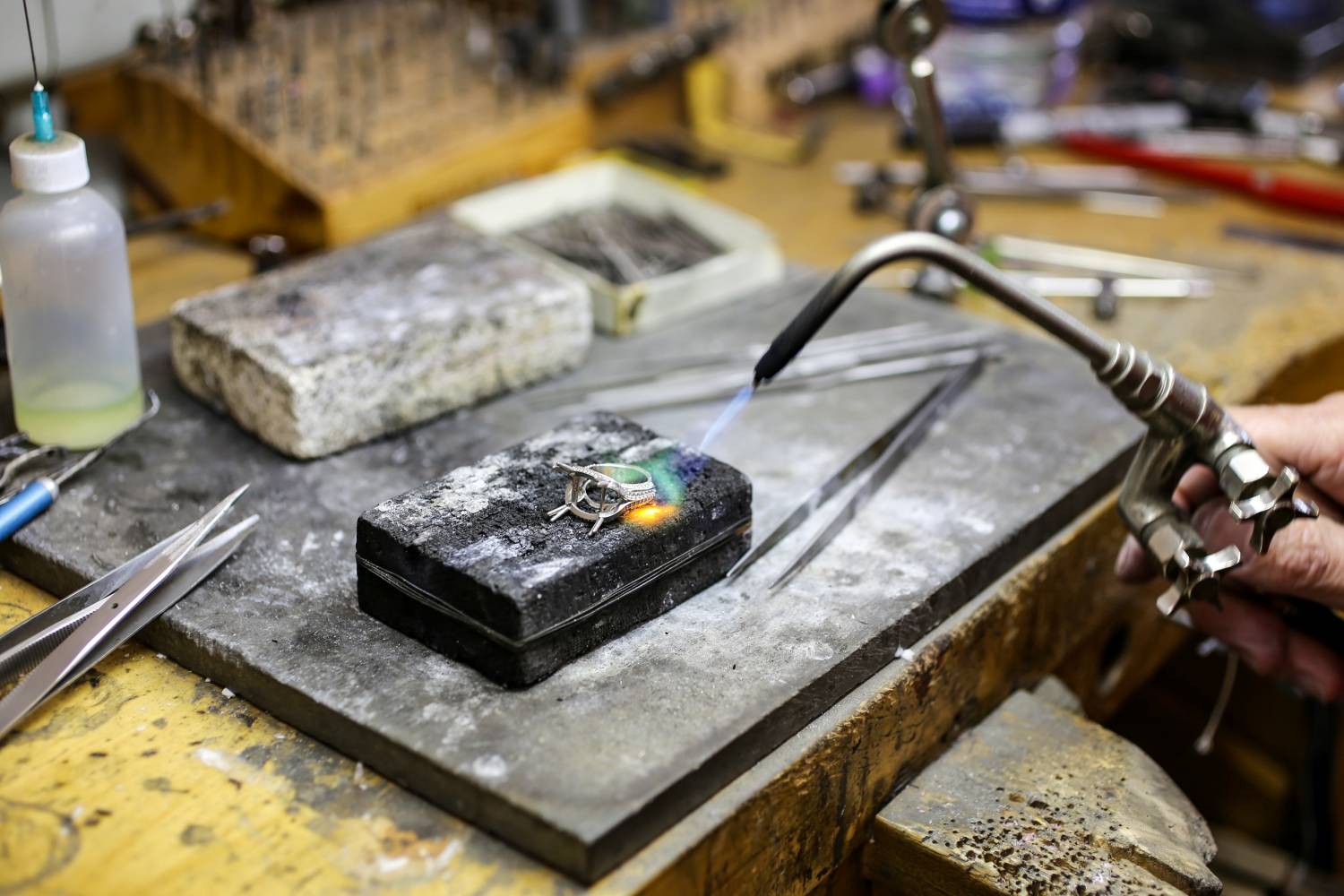 Jeweler doing custom work and heating up a ring to continue work.