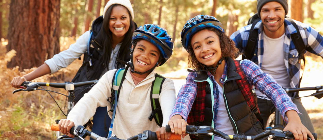 Family biking in woods with electric books