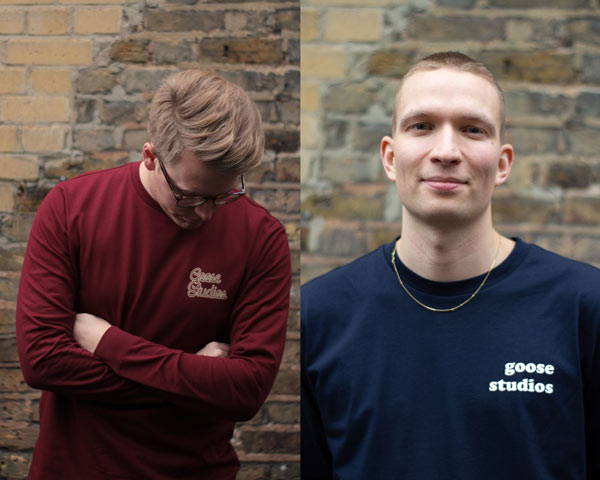 Man wearing organic cotton burgundy long sleeve t-shirt with light taupe text logo and man wearing navy blue organic cotton long sleeve t-shirt with Goose Studios logo, both from sustainable fashion brand Goose Studios