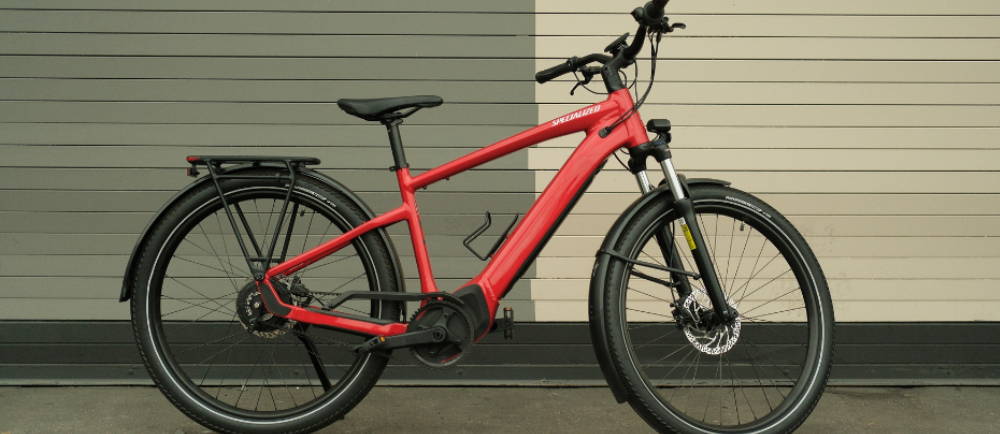 a red specialized electric bike against a wall