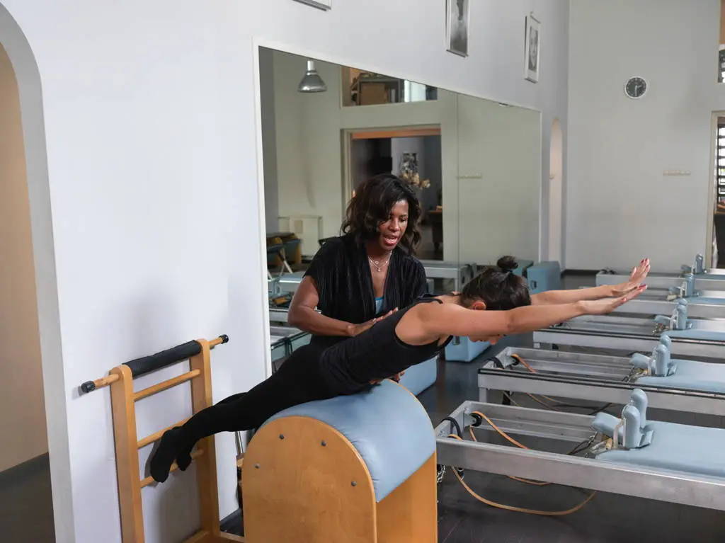 Marjorie Oron guiding a client on the Gratz Pilates Ladder Barrel. Reformers in the background