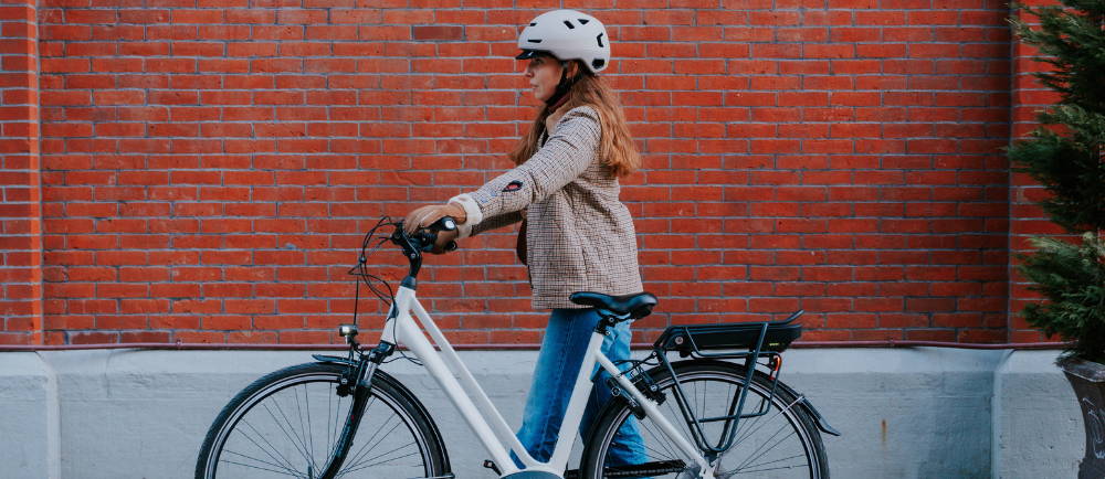 a woman standing next to a white Gazelle Medeo electric city bike