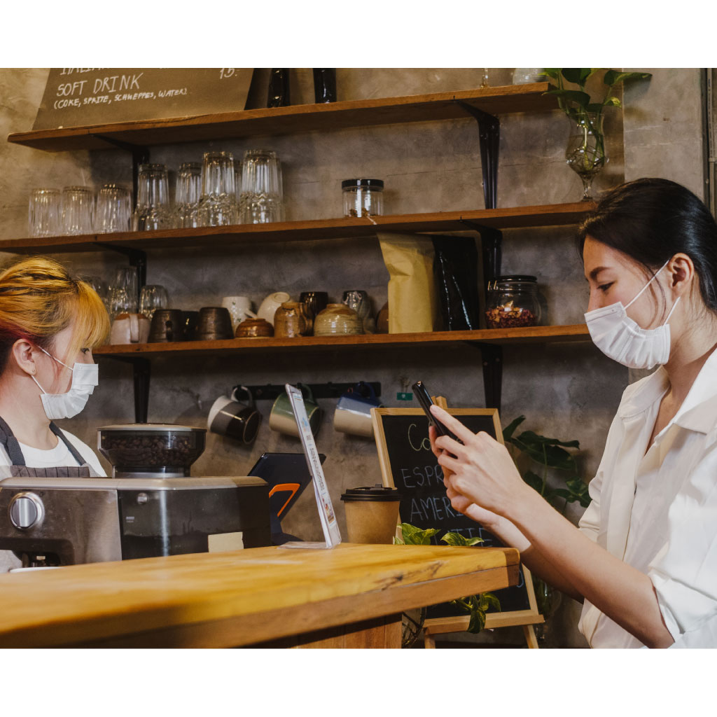 Young female wear face mask self service use mobile phone pay contactless restaurant
