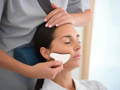 woman treating a client with gua sha massage