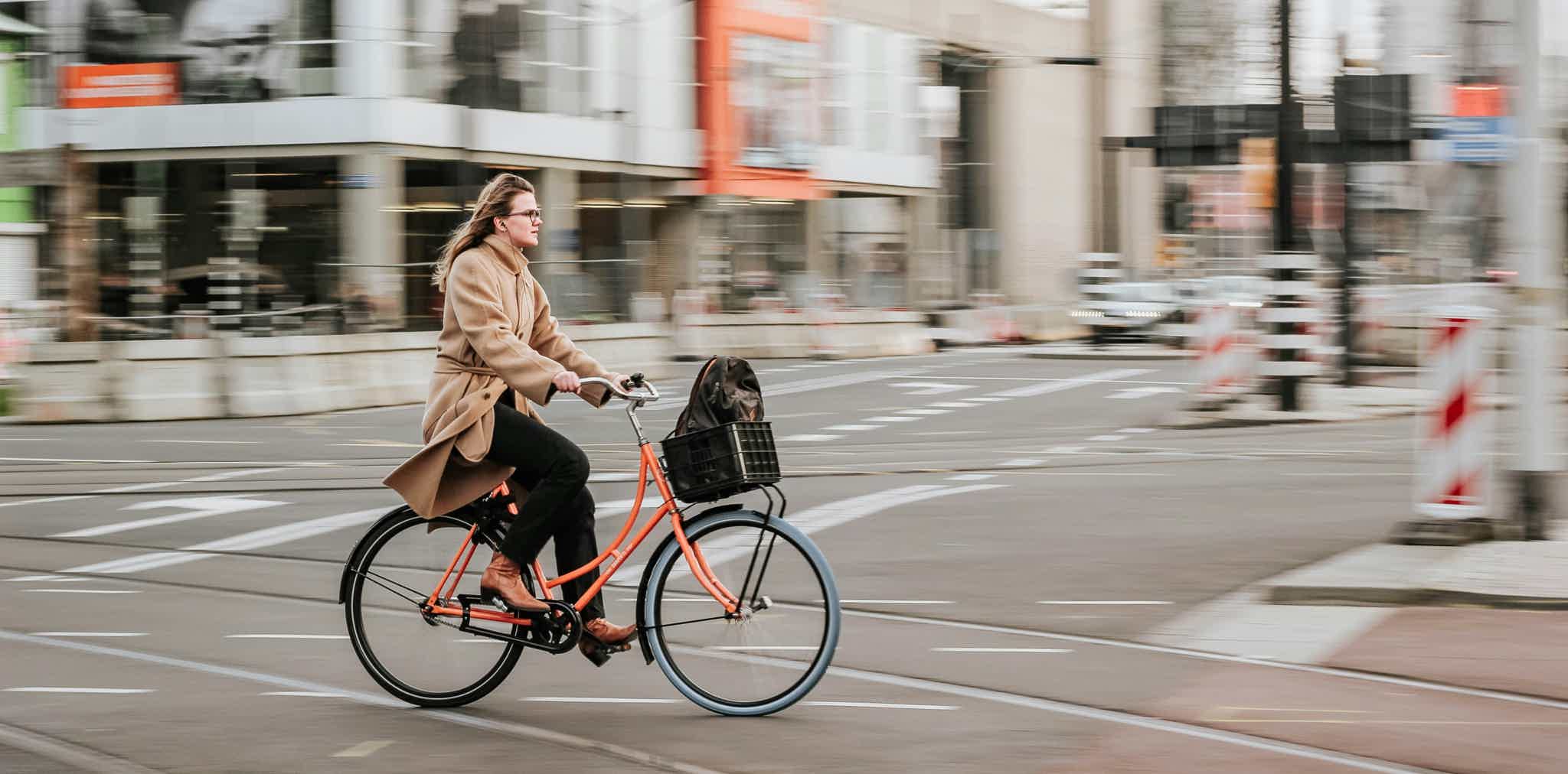 Imagen de recurso de una mujer paseando con su e-bike por la ciudad.