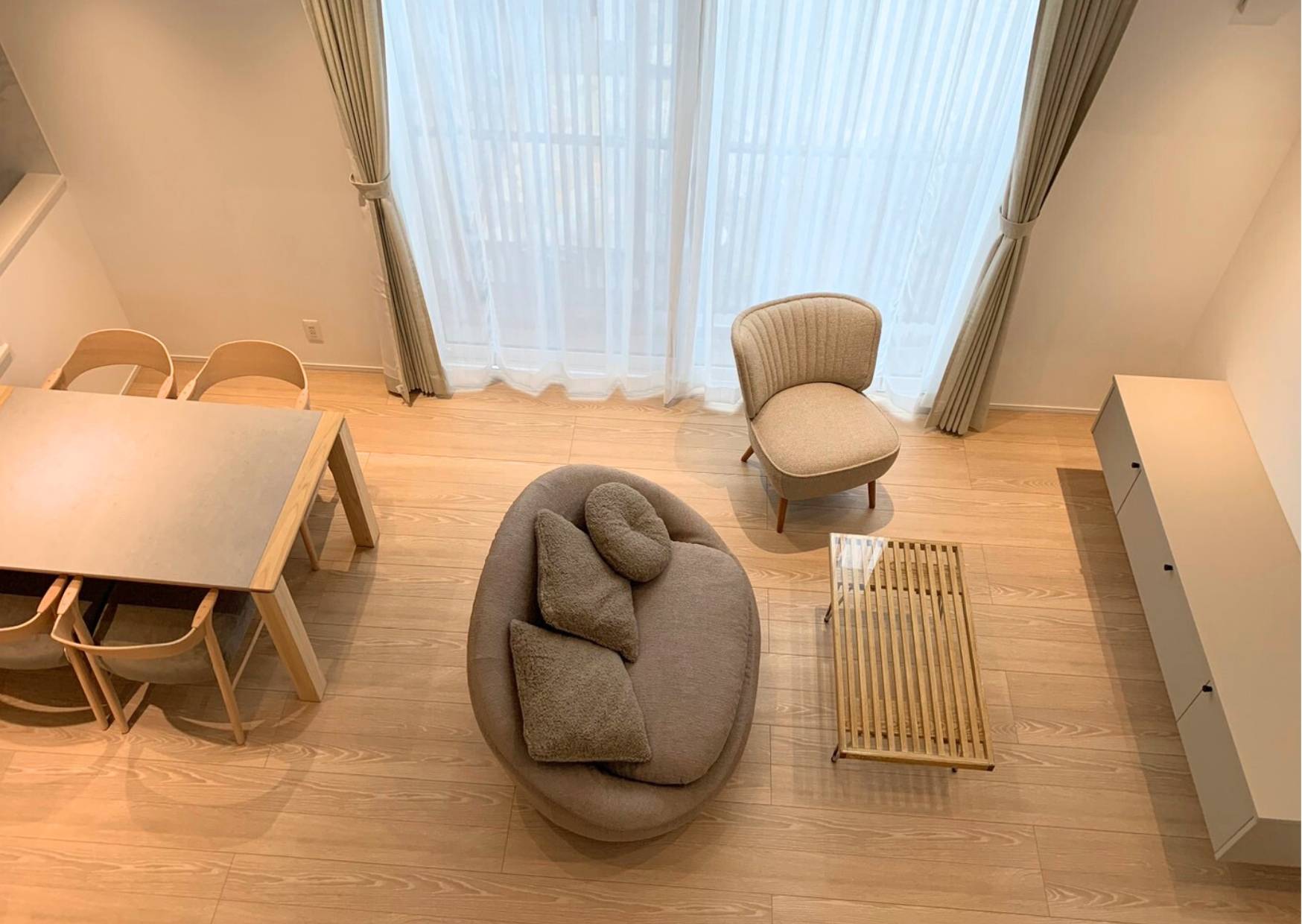 丸いフォルムのソファとナチュラル家具が調和した明るいリビングインテリア