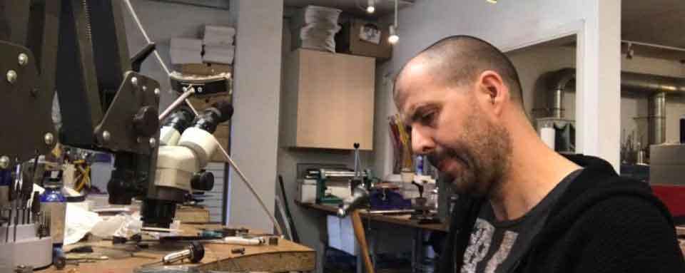 Chris Parry making memorial jewellery at his bench in his workshop in kent, uk. The man behind special jewellery made from ashes.