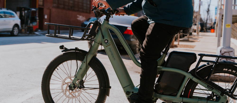 a man riding a Momentum PakYak E+ electric cargo bike in the city