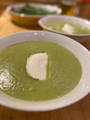 a bowl of pea soup with ricotta cheese in it.