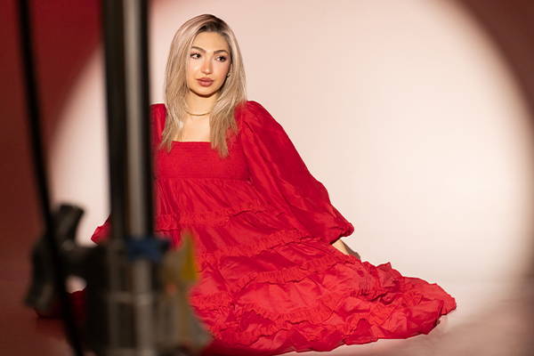 Woman in a red dress posing for a fashion photoshoot
