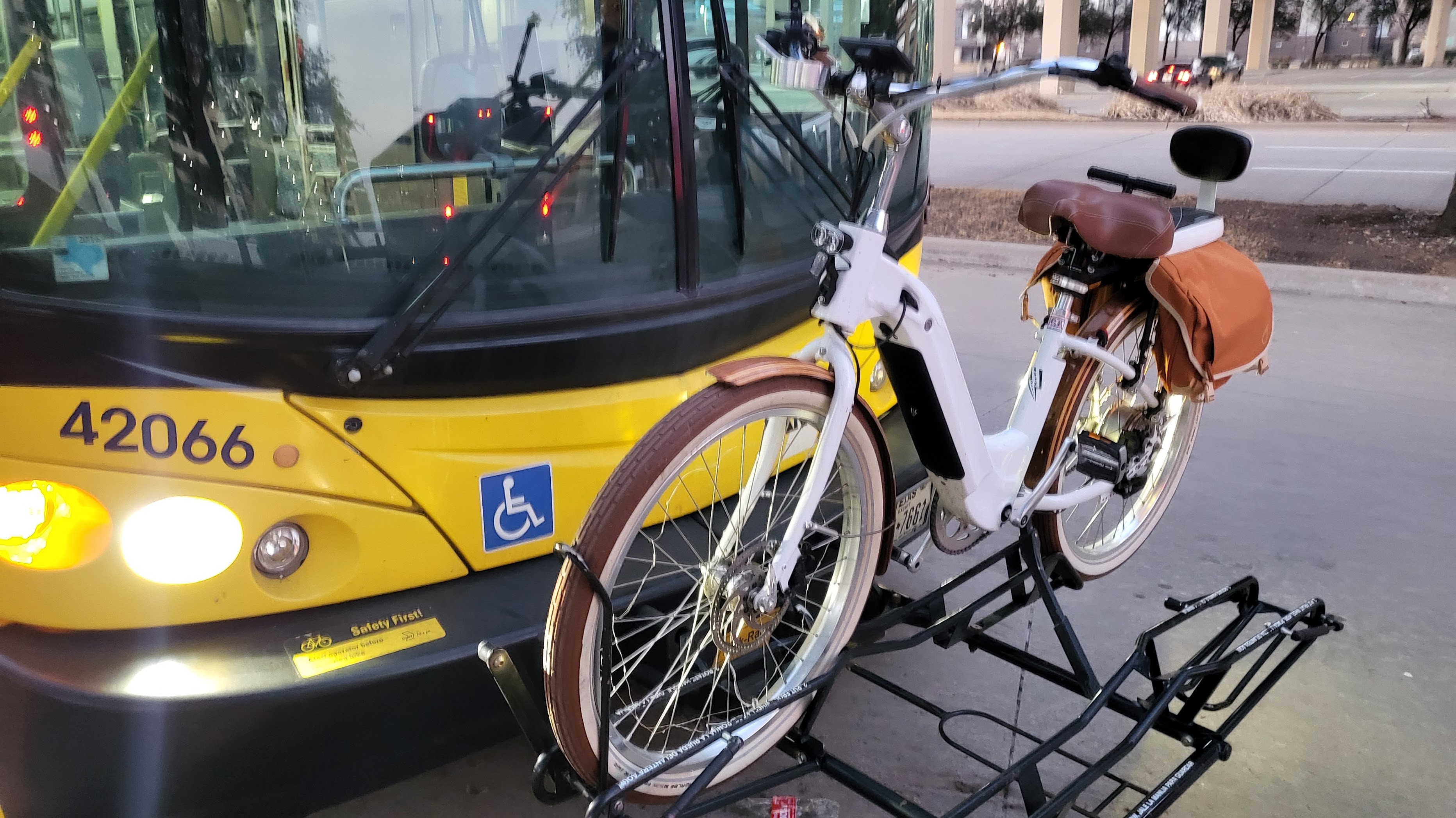 Electric bicycle mounted on the front-rack of a public bus.