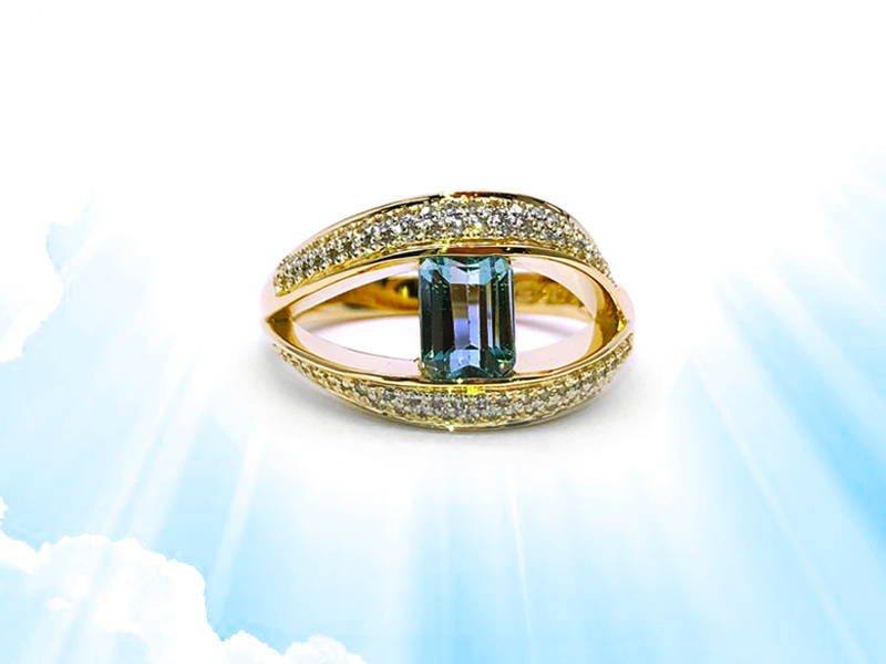 Yellow gold ring with a large opening paved with small diamonds linked by an emerald cut blue topaz.